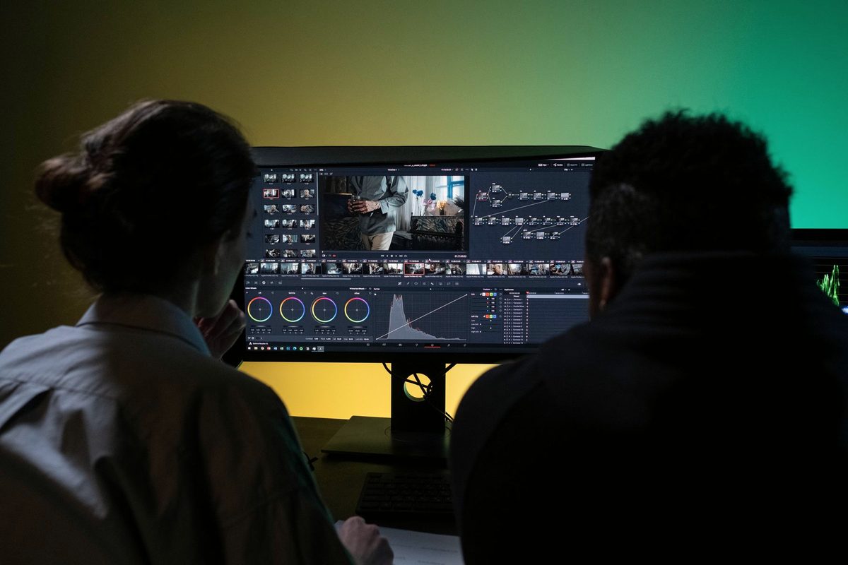 Two editors reviewing a cut together on a studio monitor